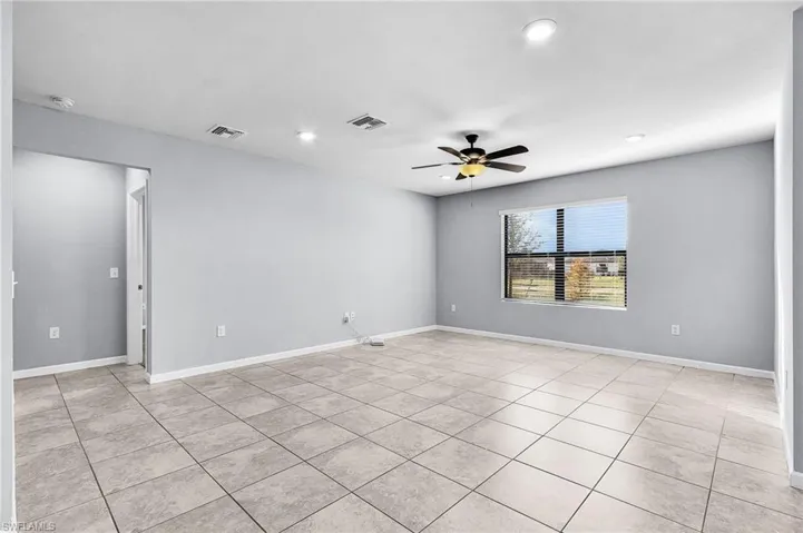 Living room featuring ceiling fan, recessed lighting, tile floors, overlooking water view