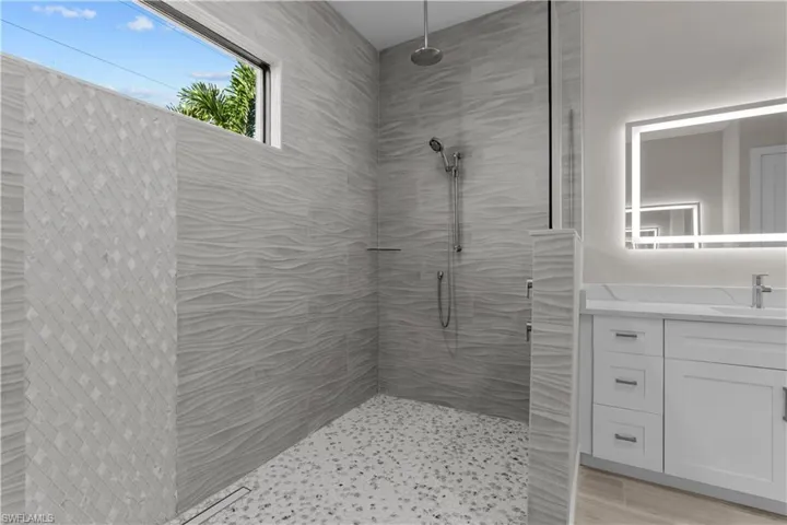 Bathroom with vanity and a tile shower
