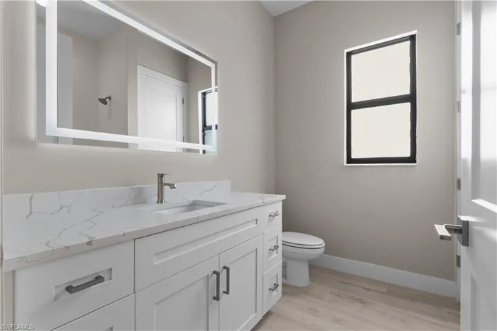 Bathroom featuring a healthy amount of sunlight, vanity, and toilet