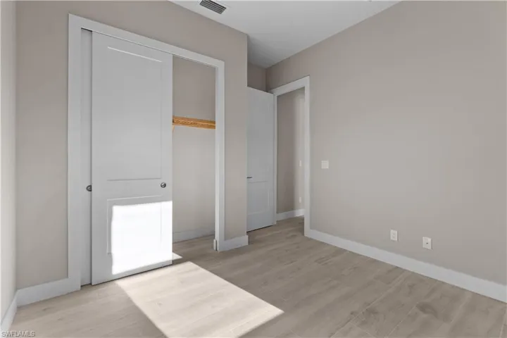 Unfurnished bedroom featuring light wood-type flooring and a closet