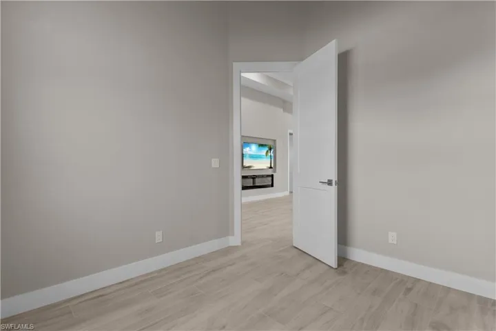 Spare room with a high ceiling and light wood-type flooring