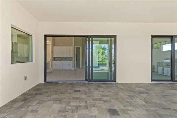View of exterior entry with a patio area
