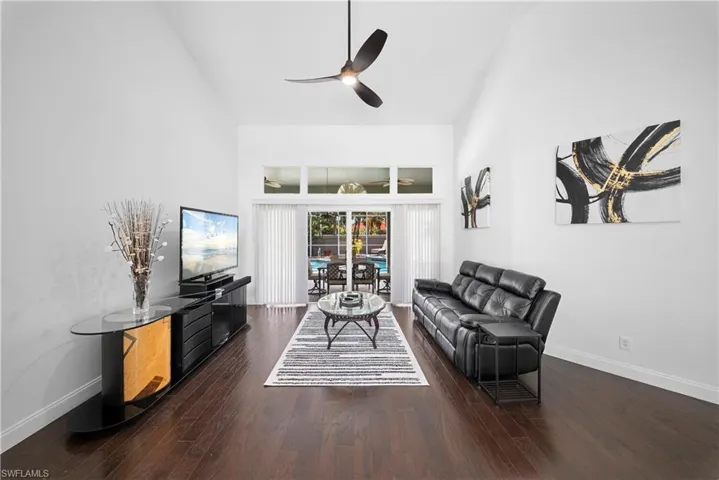 Vaulted ceilings, wood-finish flooring, transom windows, and a multi-blade ceiling fan