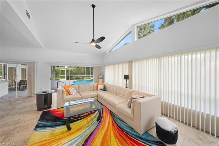 Vaulted ceilings with transom windows, tile flooring, and a modern ceiling fan