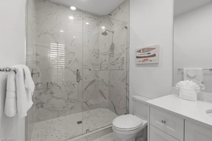 Bathroom with a marble finish shower, vanity, and marble finish flooring