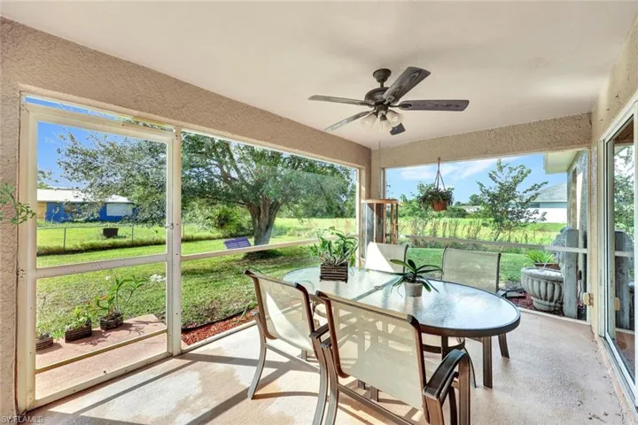 Screened rear yard lanai with ceiling fan.