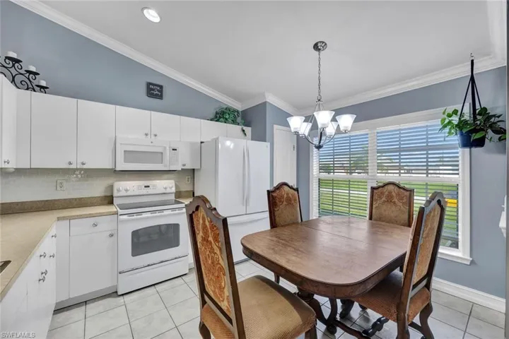 Tiled floor Eat in -Kitchen featuring vaulted ceiling, decorative light fixtures, recessed lighting & pantry.