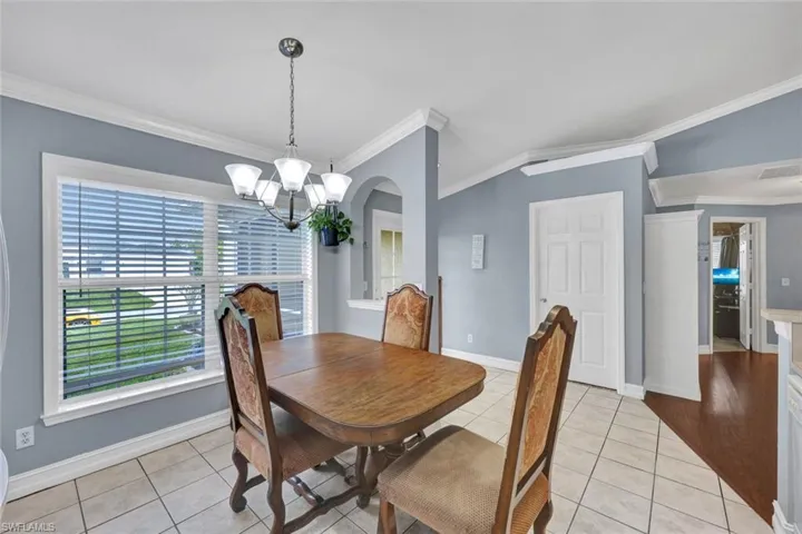 Tiled dining area featuring crown molding