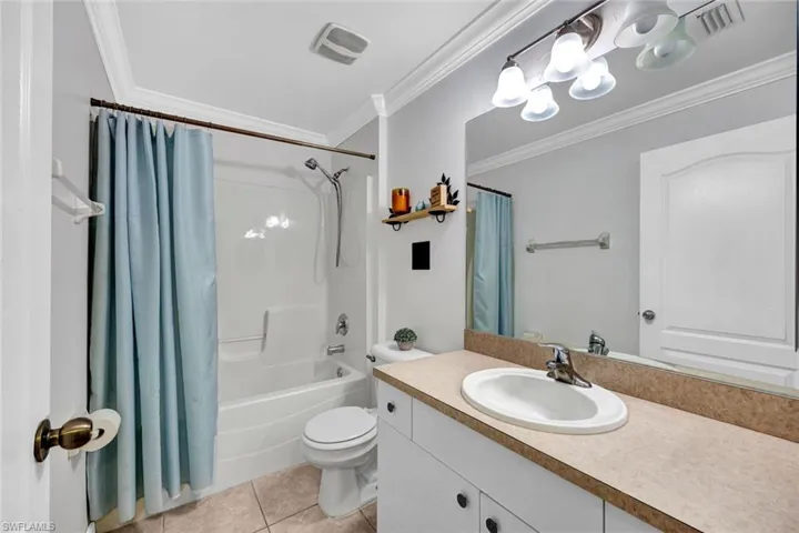 Full Hall bathroom with ornamental molding, vanity & tile flooring.