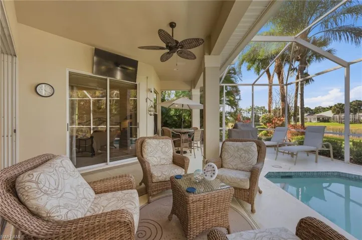 Sunroom / solarium with a pool, a patio area, a ceiling fan, and outdoor dining space