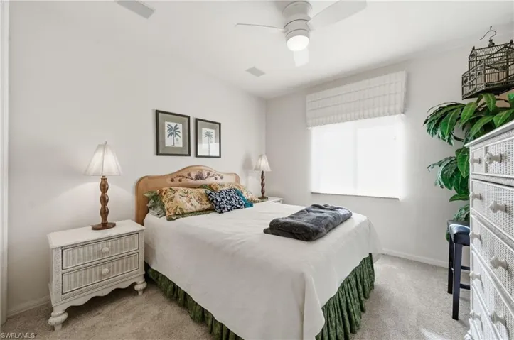 Bedroom with light carpet and a ceiling fan