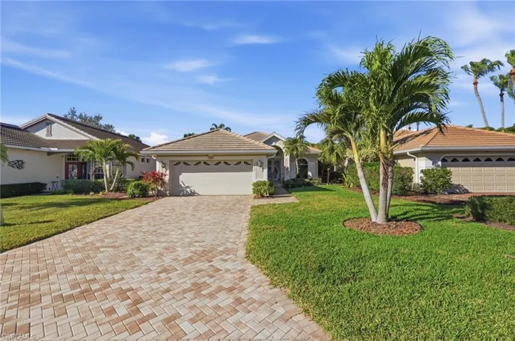 Single story home with a front yard, an attached garage, decorative driveway, and stucco siding