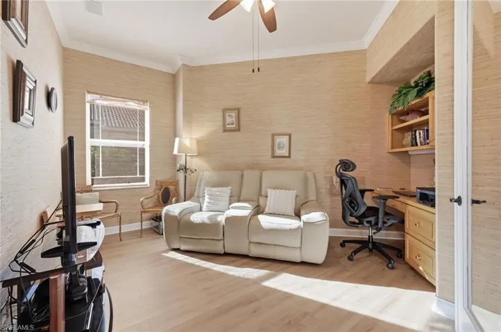 Office space featuring light wood finished floors, ornamental molding, and ceiling fan