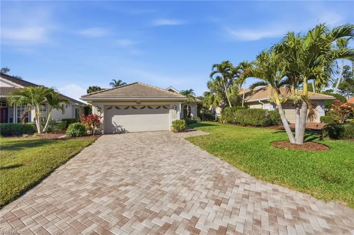 Ranch-style house with a front lawn, decorative driveway, a garage, and stucco siding
