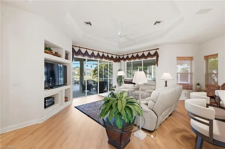 Living room featuring built in features, light wood finished floors, and a ceiling fan