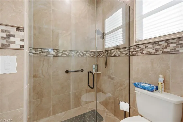 Full bathroom featuring a stall shower and toilet