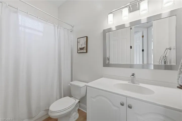 Bathroom featuring a shower with curtain, vanity, and light wood-type flooring