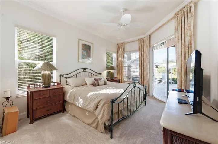 Bedroom with access to outside, multiple windows, ornamental molding, carpet floors, and ceiling fan