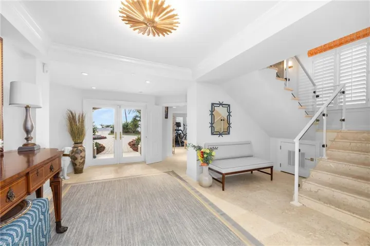 Entrance foyer featuring ornamental molding and french doors
