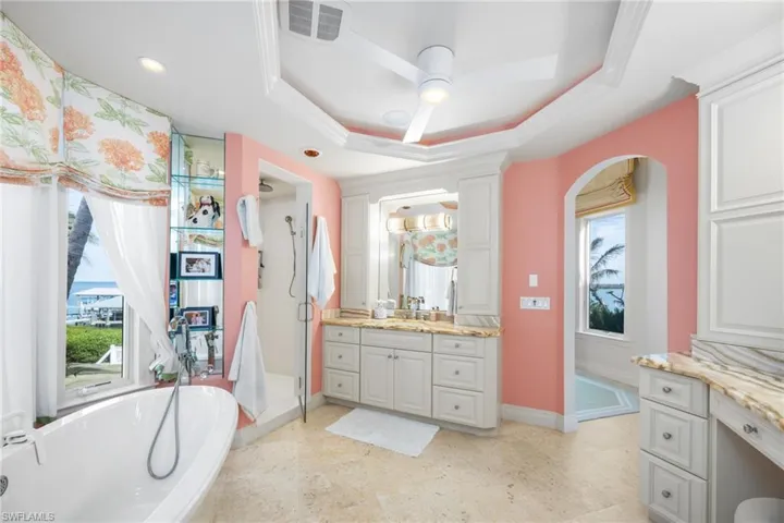 Primary bathroom his his/hers vanity areas, stand alone tub, shower and lovely ceiling features