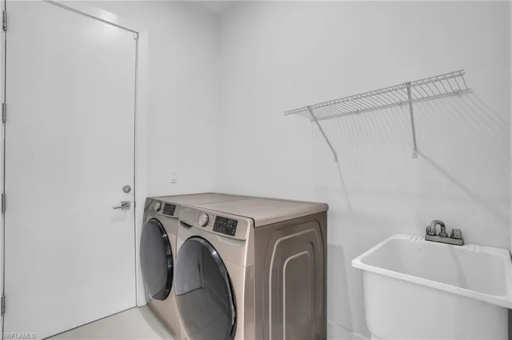 Laundry area with sink and washer and clothes dryer
