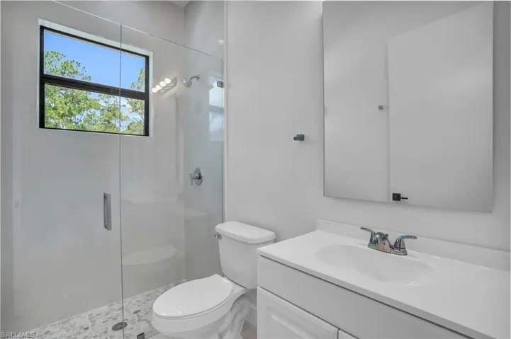 Bathroom with walk in shower, toilet, and vanity