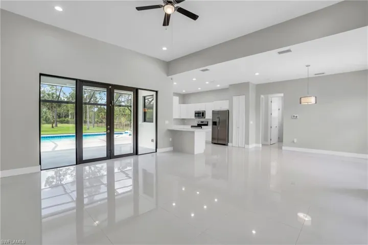 Unfurnished living room featuring ceiling fan and light tile flooring