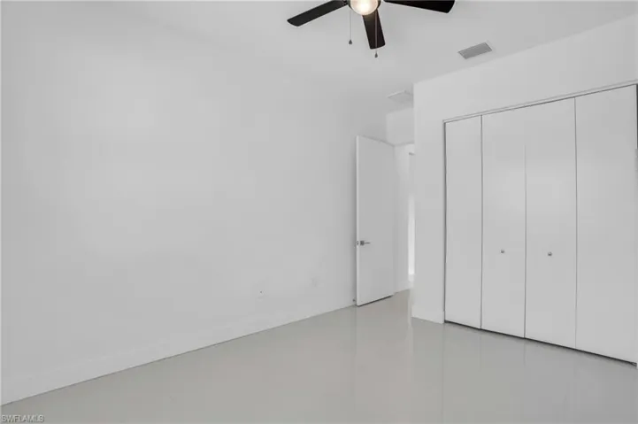 Unfurnished bedroom featuring tile floors, ceiling fan, and a closet
