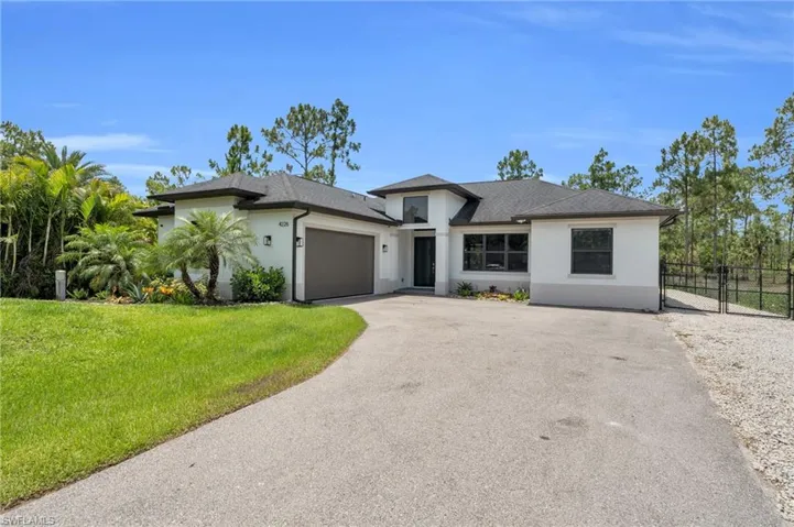View of front of home featuring a front lawn and a garage
