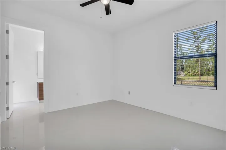 Tiled spare room with ceiling fan