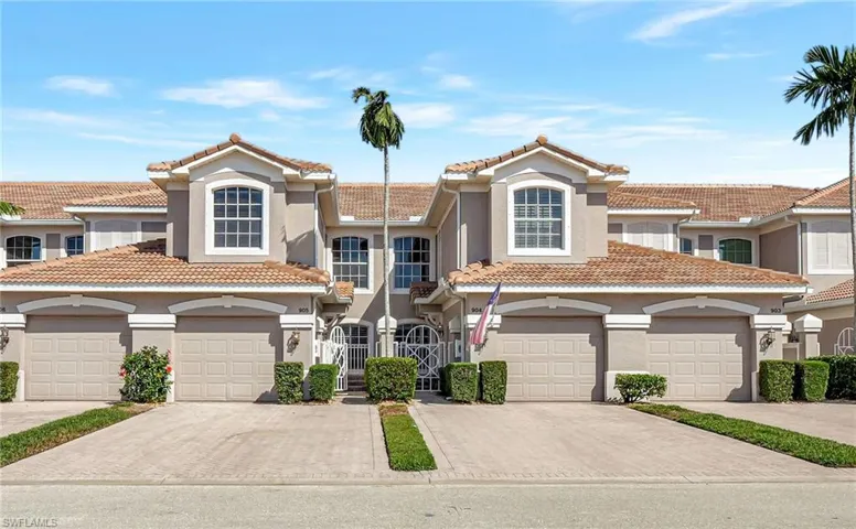 View of the coach home, featuring gated entrance, stucco siding, a new tile roof, and attached garage