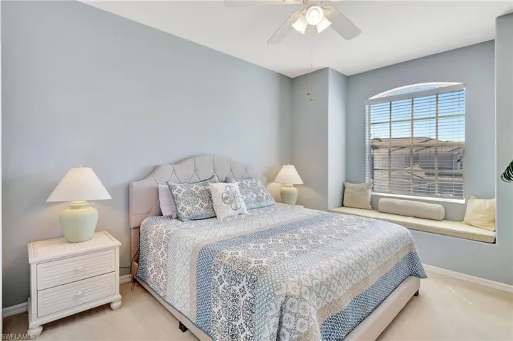 Bedroom featuring light carpet, baseboards, and a ceiling fan
