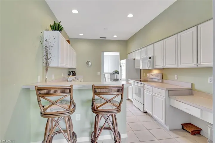 Spacious Primary Bedroom  overlooking the lake, featuring access to exterior lanai multiple windows, and ceiling fan