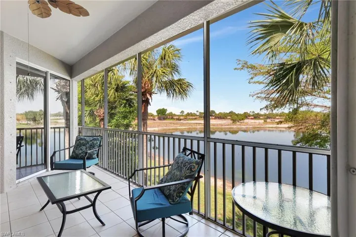 Sunroom / solarium featuring a ceiling fan and a water view