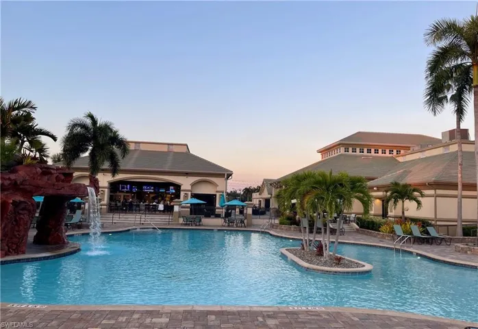 Pool at dusk featuring a community pool and a patio area