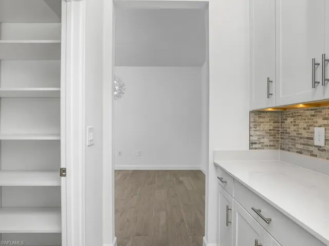 Coffee bar/butler pantry is adjacent to large walk-in pantry with custom shelving.