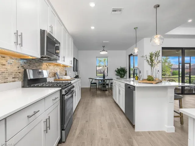Oversized island and floor plan with open kitchen/dining/great room make this home perfect for entertaining. Note the over and under cabinet lighting!