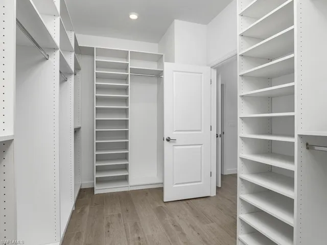What a closet! Owner closet with all custom built-ins for easy storage and organization and walk-through to the laundry room.