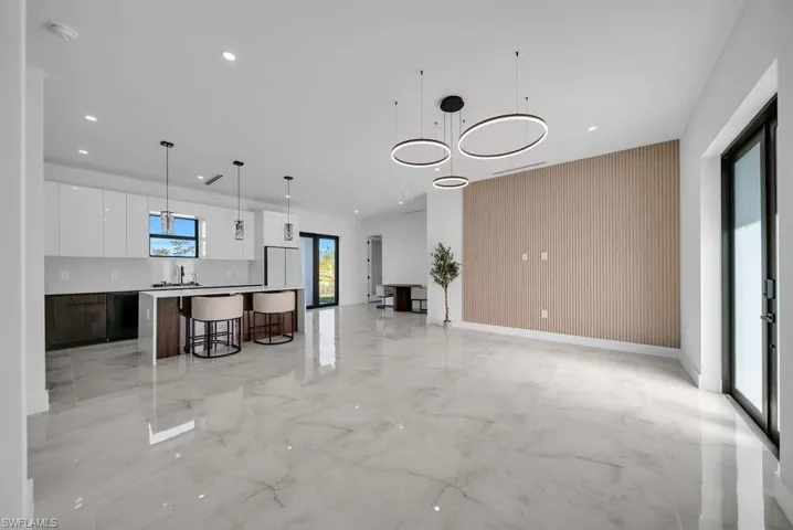 Kitchen with white cabinetry, pendant lighting, modern cabinets, open floor plan, and a kitchen island