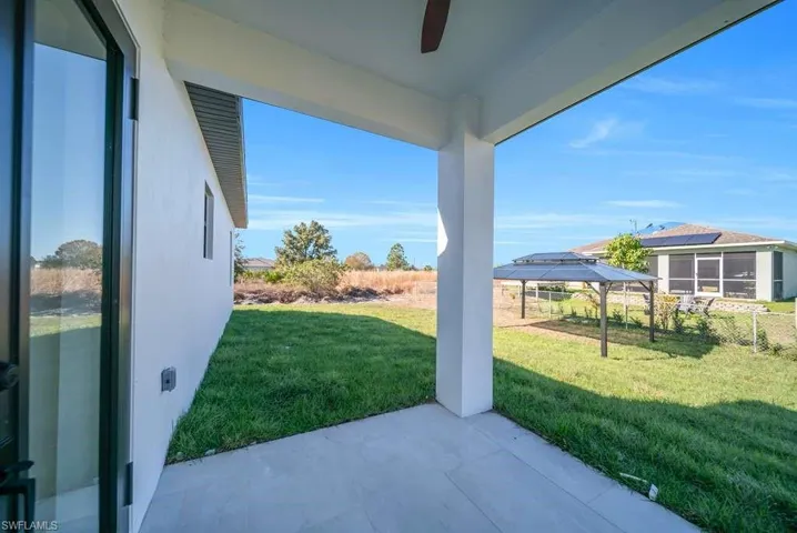 View of green lawn with a patio area