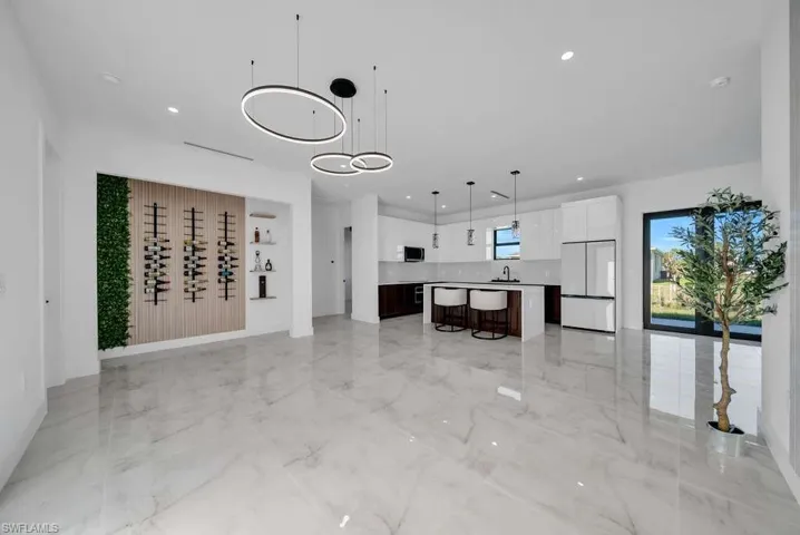 Living area with light marble finish floors and recessed lighting