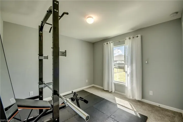 Neutral-toned walls, neutral carpeting, and a single-pane window with a white curtain rod