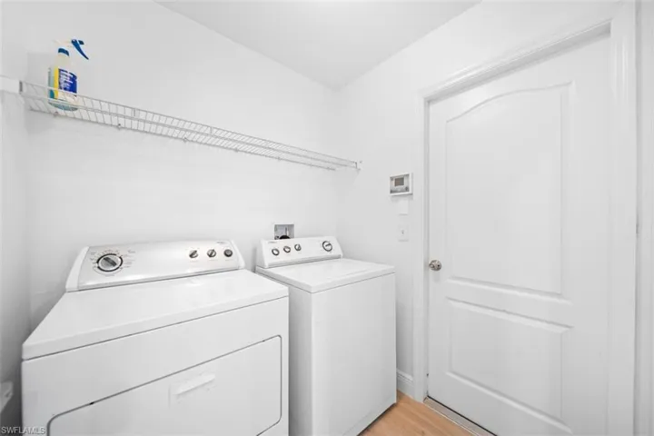 Laundry room featuring washing machine and dryer and light wood-style floors