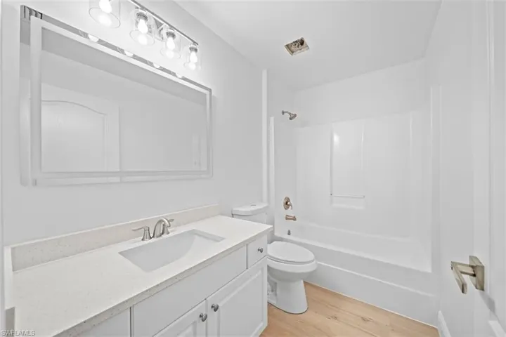 Full bath featuring vanity, light wood-type flooring, and  shower combination