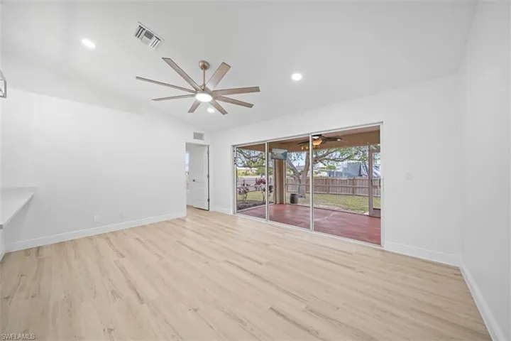 Unfurnished room featuring light wood-type flooring, ceiling fan, vaulted ceiling, and recessed lighting