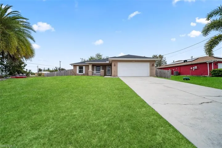 Single story home featuring an attached garage, concrete driveway, and stucco siding