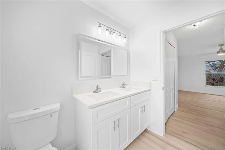 Full bathroom with double vanity and light wood finished floors