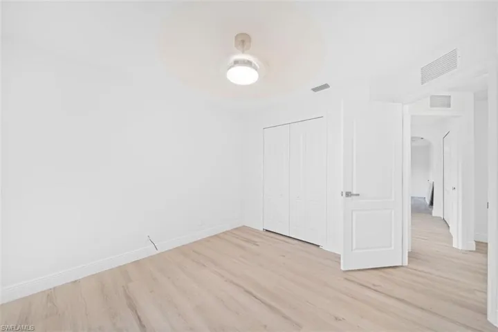 Unfurnished bedroom featuring light wood-style flooring, a closet, and ceiling fan