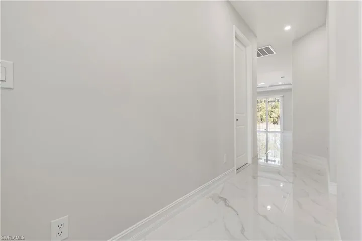 Hall featuring marble finish floor, visible vents, baseboards, and recessed lighting
