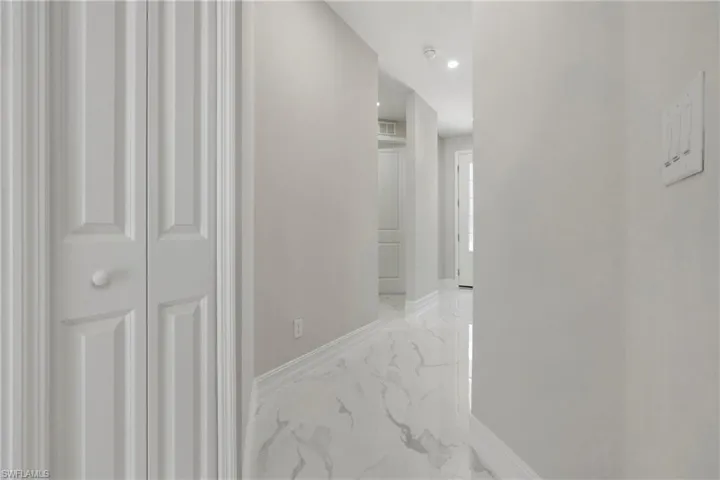 Hall featuring marble finish floor, visible vents, and baseboards